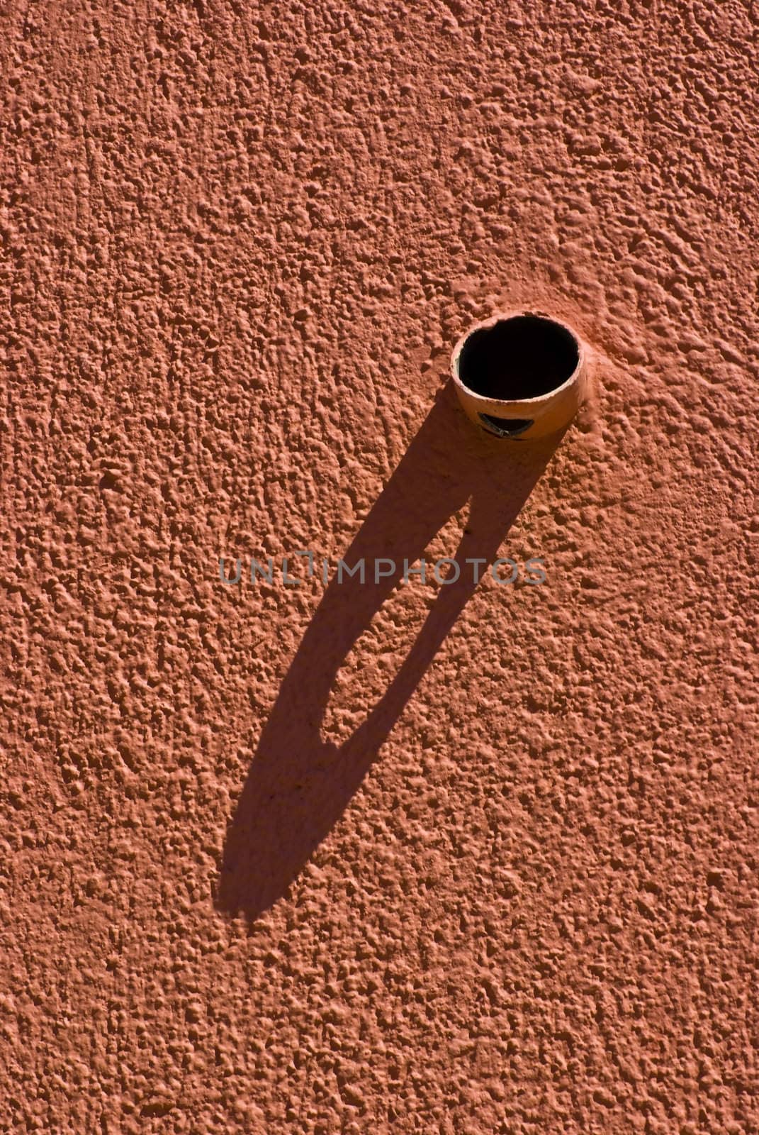 Shadow of a pipe protruding from the wall.
