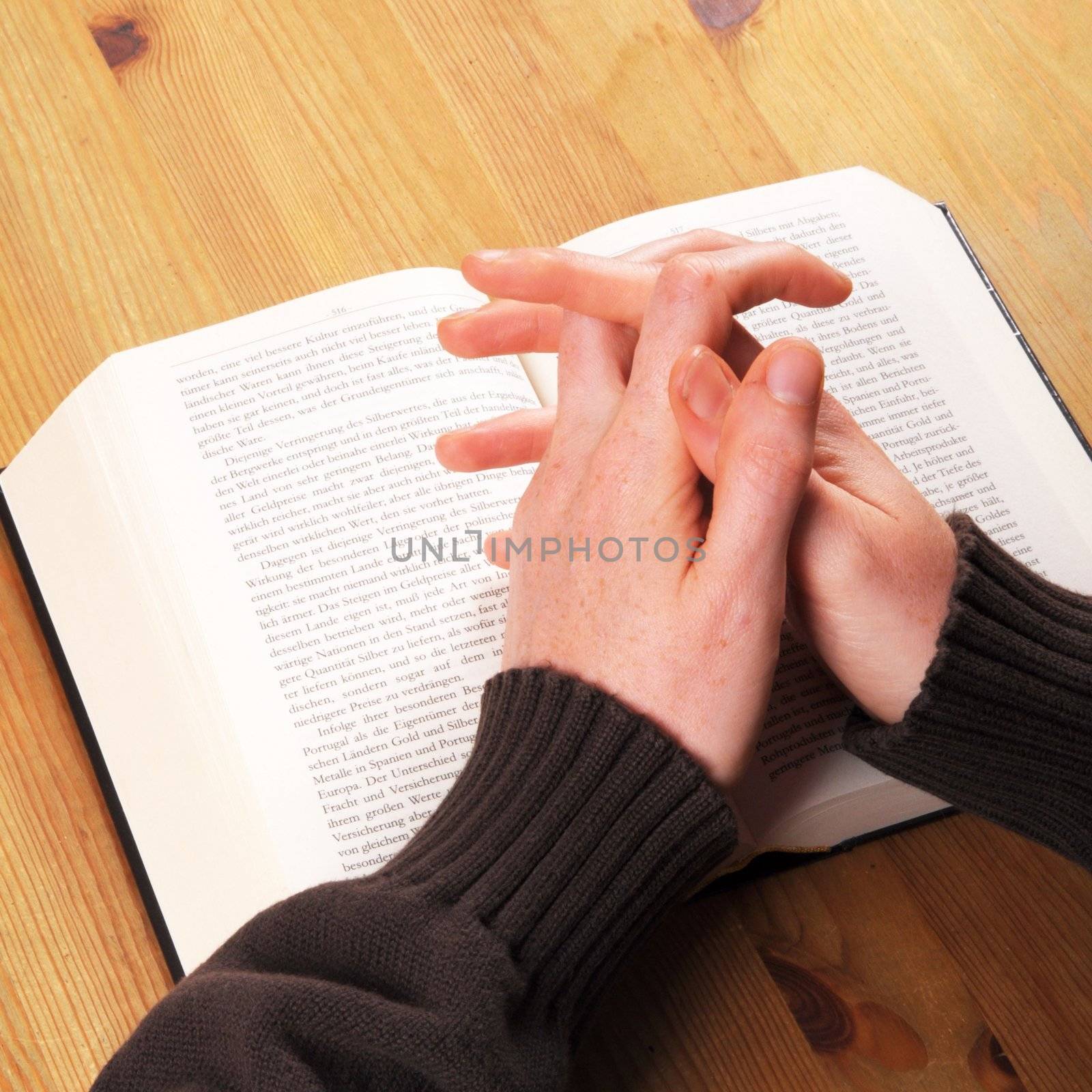 praying hands and book showing christian religion concept