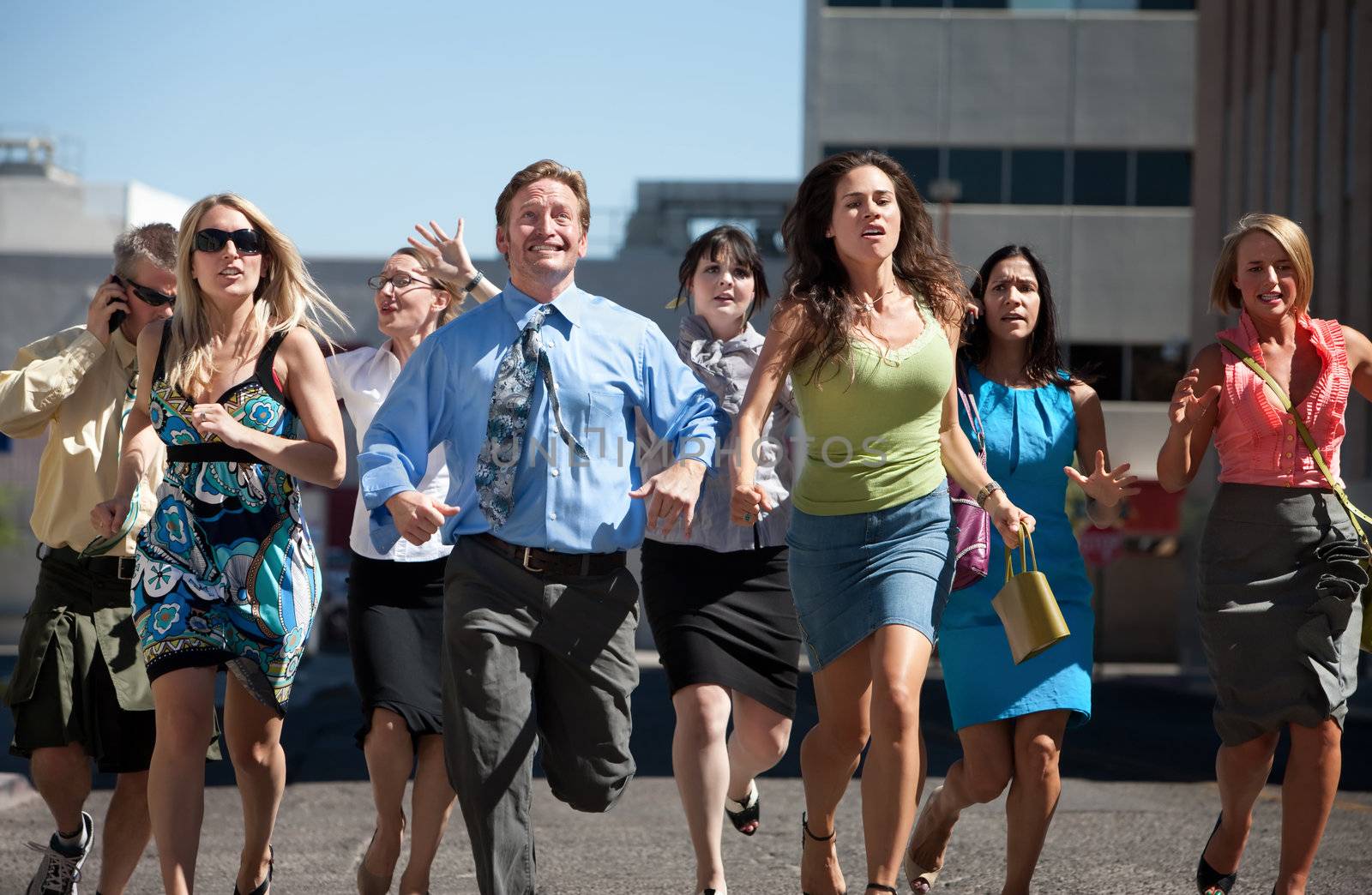 Group of hard working business men and women run down city street.