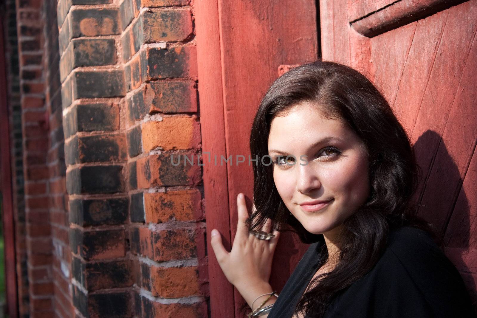 A pretty young woman in her twenties posing in a rustic setting. 