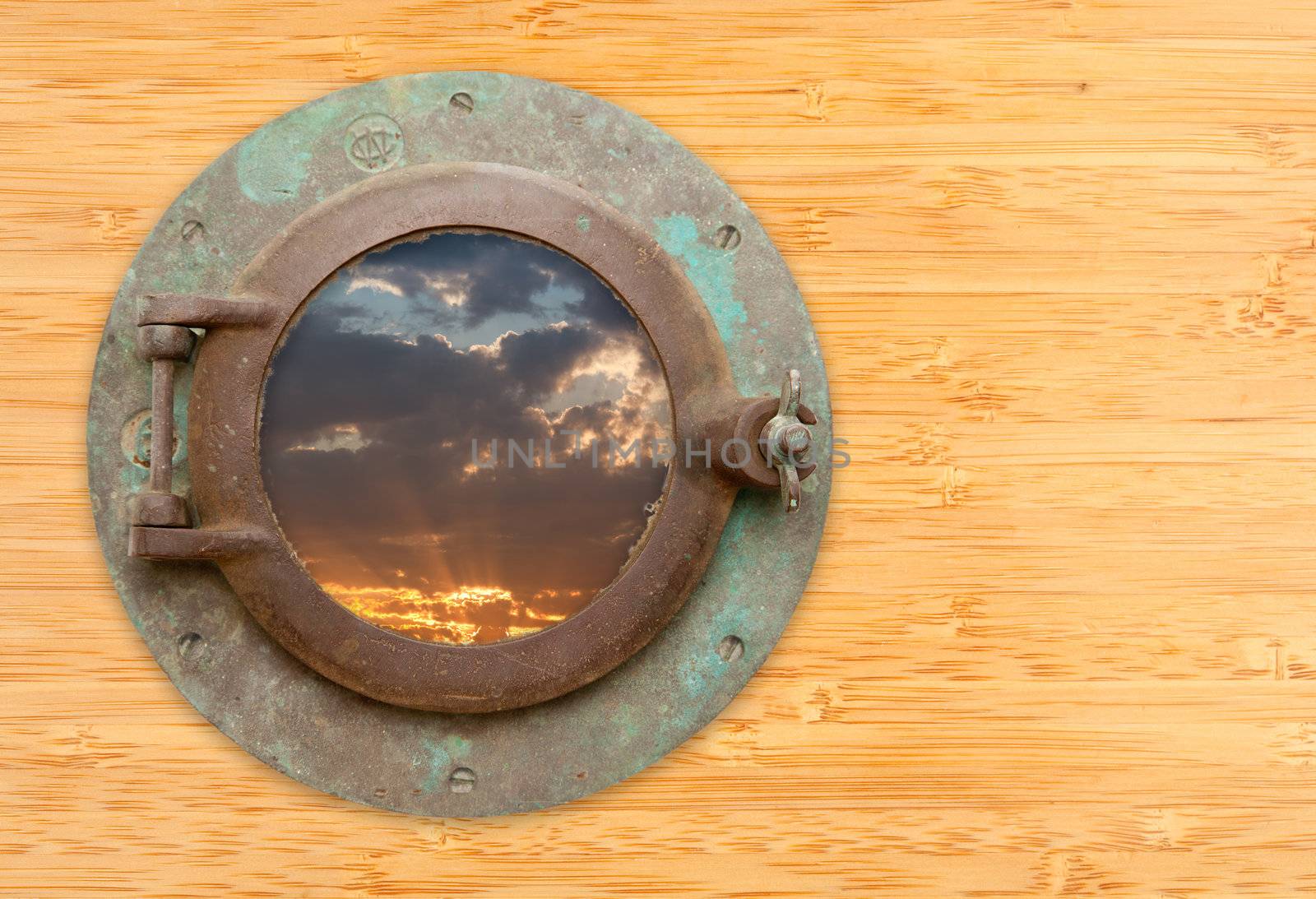 Antique Porthole with View of Sunset on a Bamboo Wall Background.
