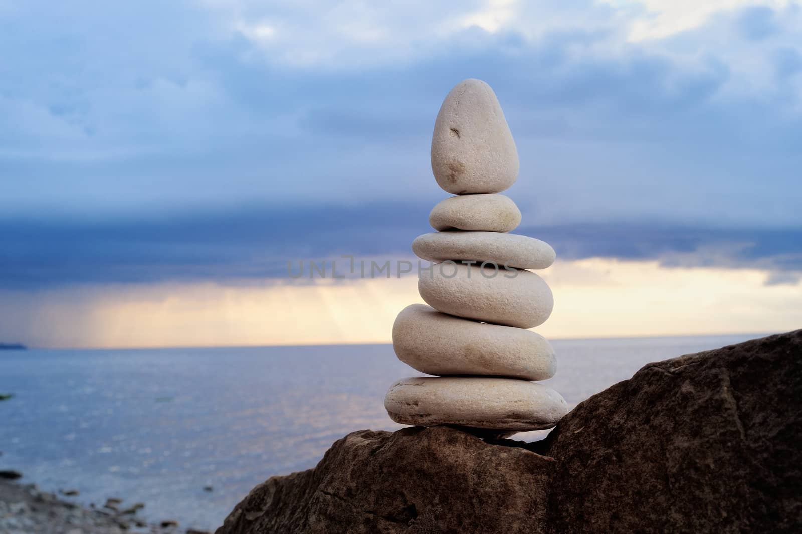 Balancing of white pebbles on the sea coast