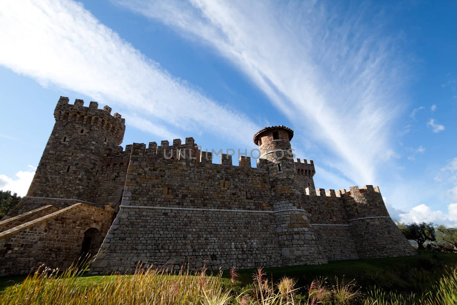 A stone castle with hilly mountains in the background