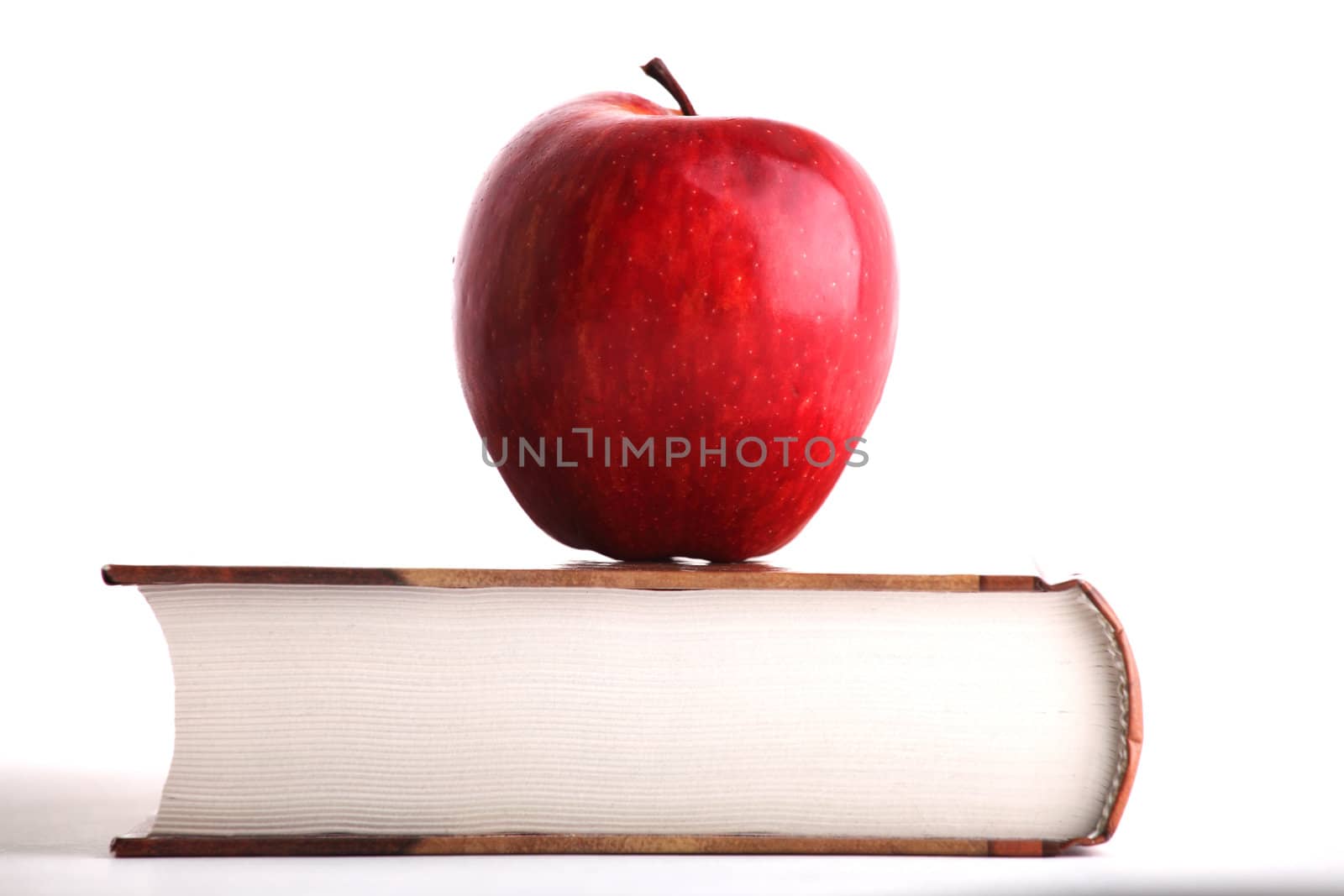 Red apple on the big book on white background