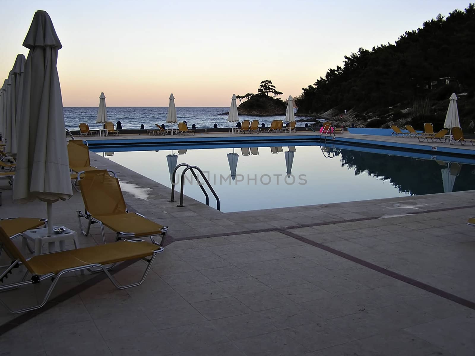 Swimming pool near coastline at the end of the day.