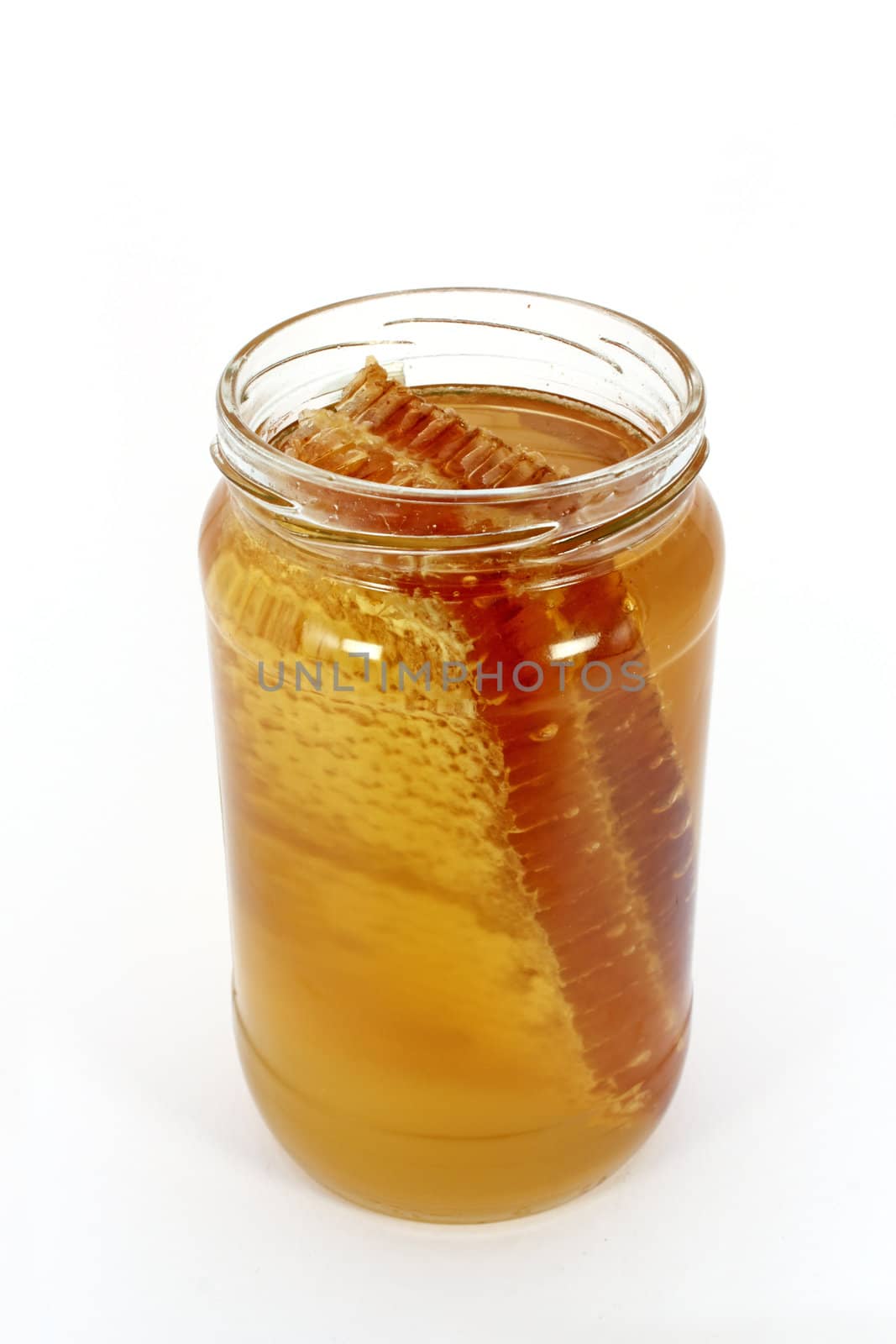 Glass jar full of honey with honeycomb, isolated on white