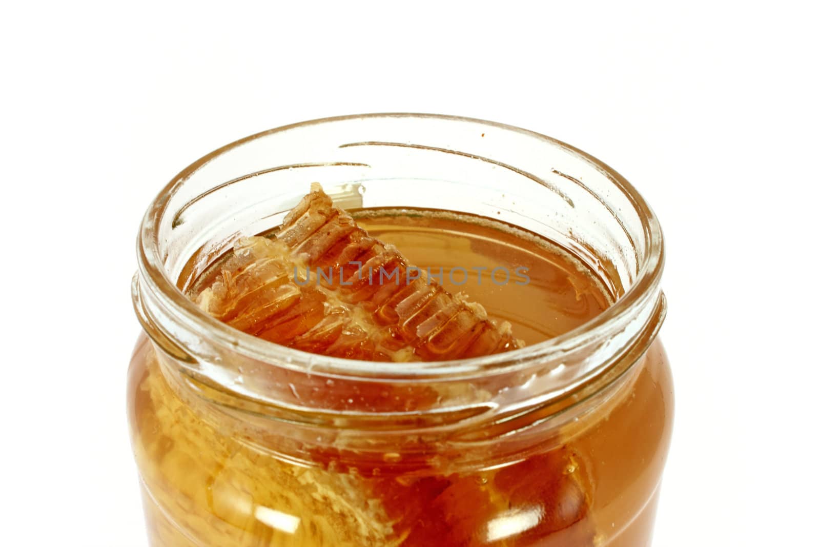 Glass jar full of honey with honeycomb, isolated on white