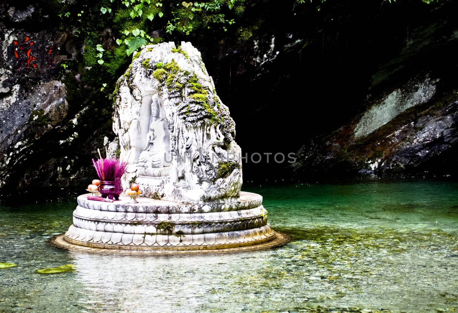 A white buddhist shrine in the mountains of Dali, China in crystal clean water