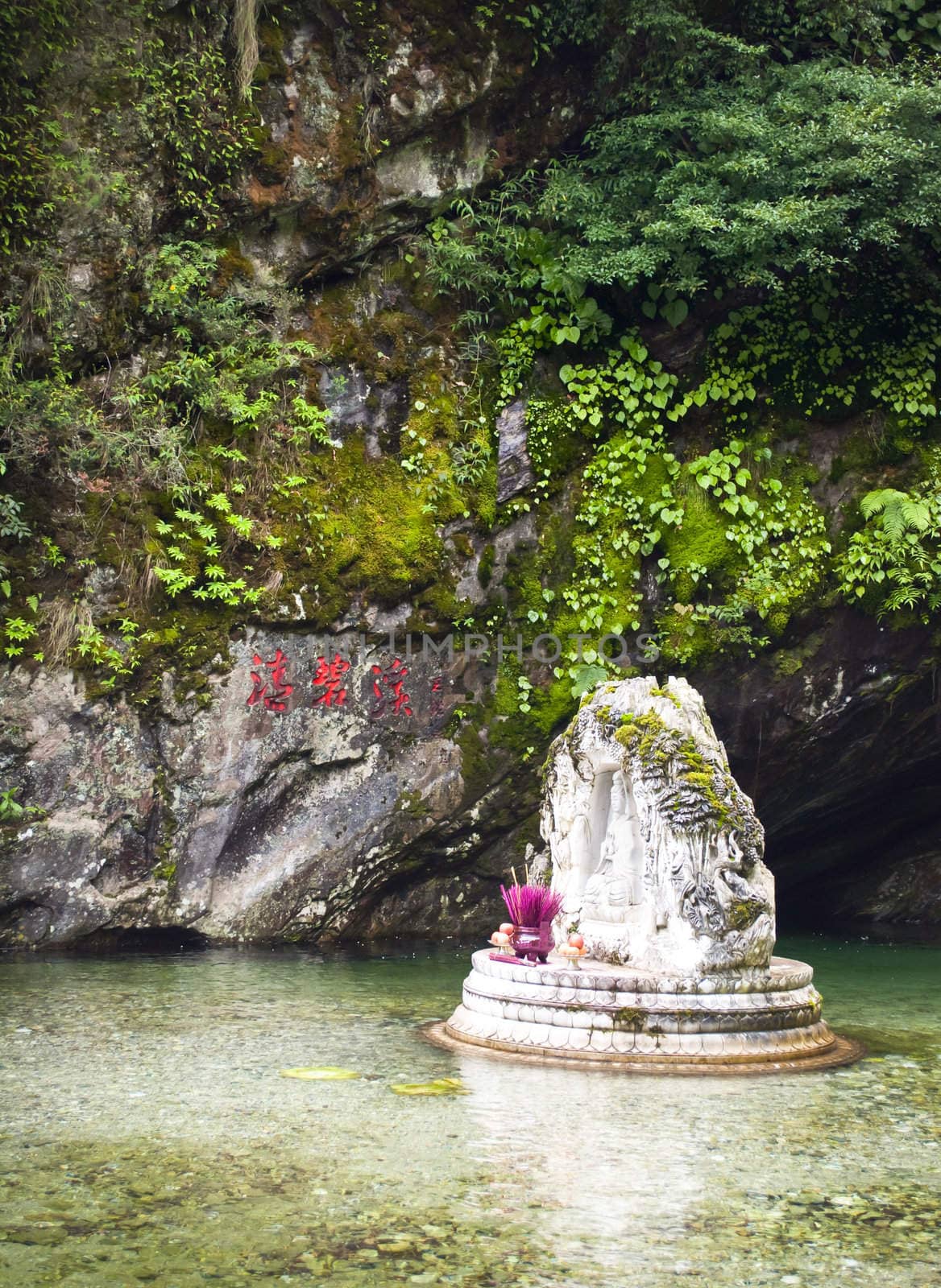 A white buddhist shrine in the mountains of Dali, China in crystal clean water