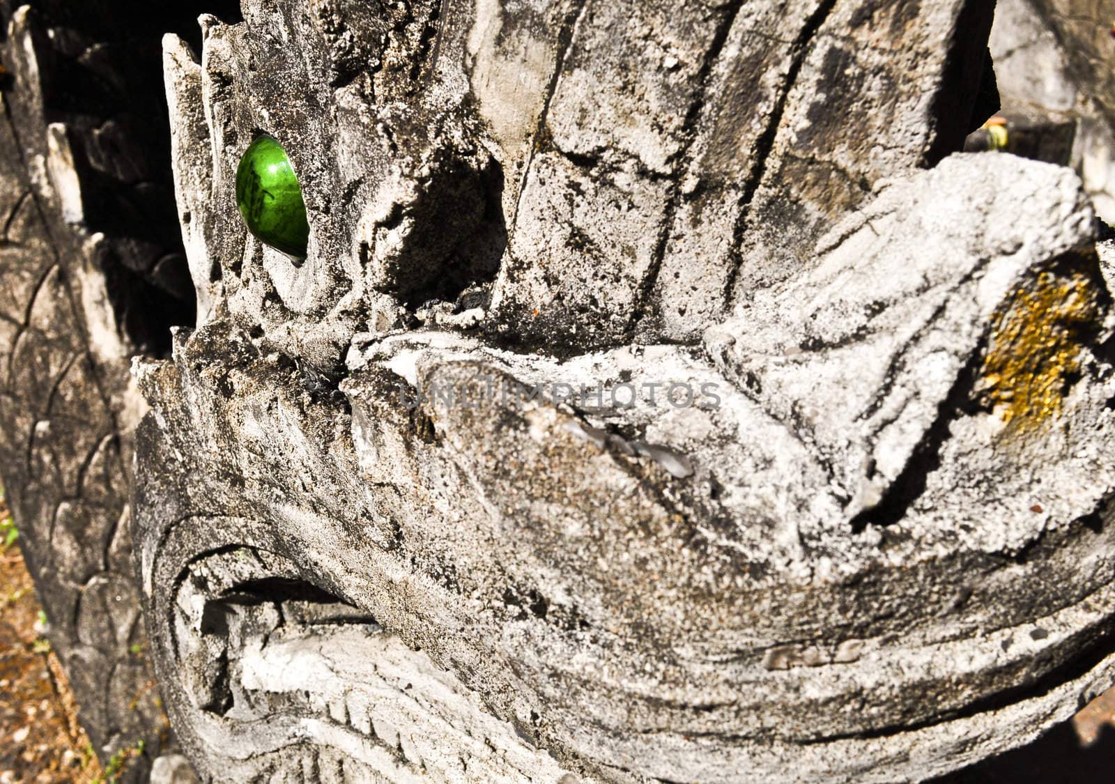 A green eye of a dragon statue close-up at a buddhist temple in asia