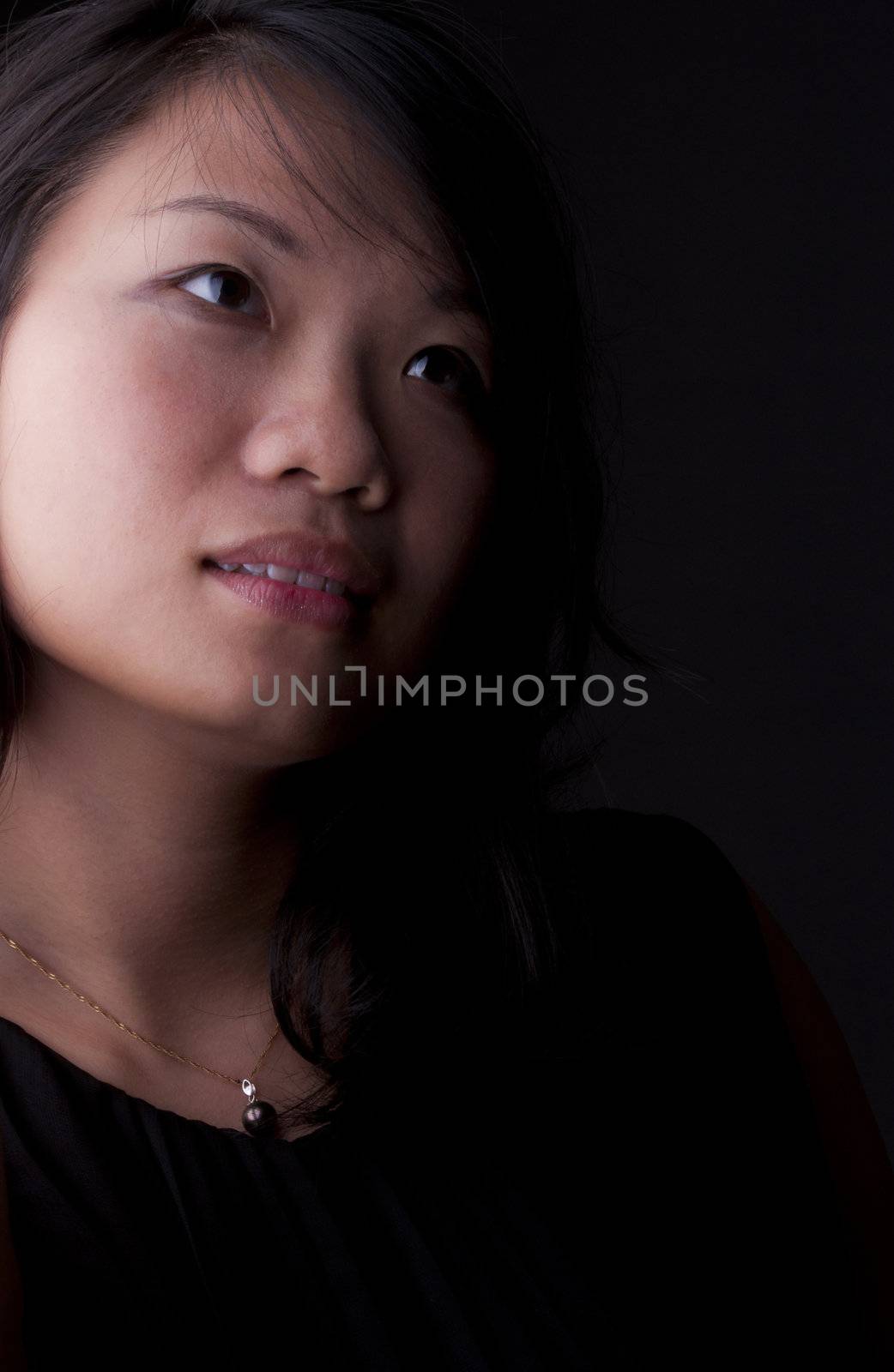 Beautiful Chinese woman with soft look isolated on black