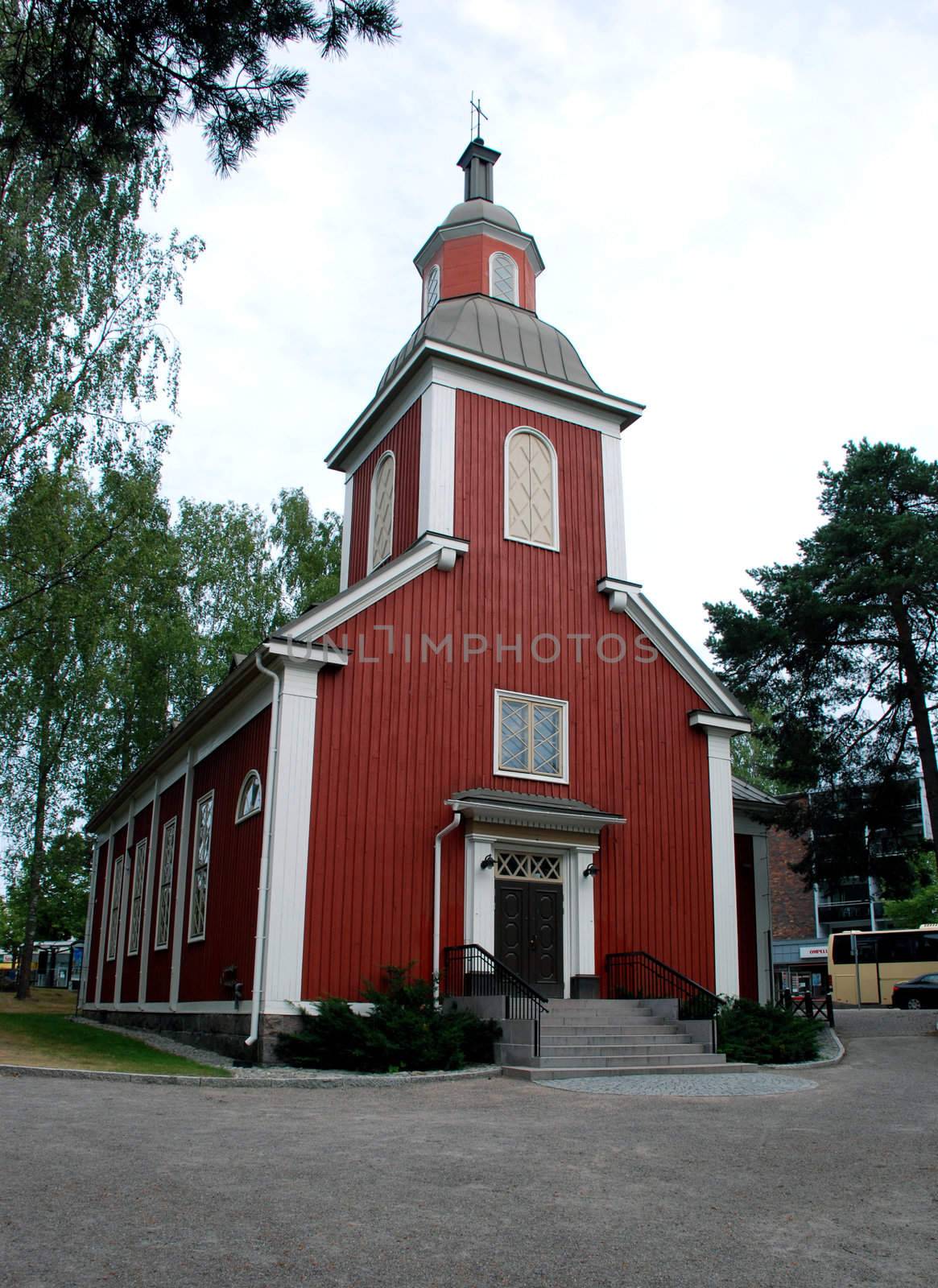 A sort of church in Hyvinkaa, A town not far from Helsinki.
The church is red and rounded by trees, by nature.