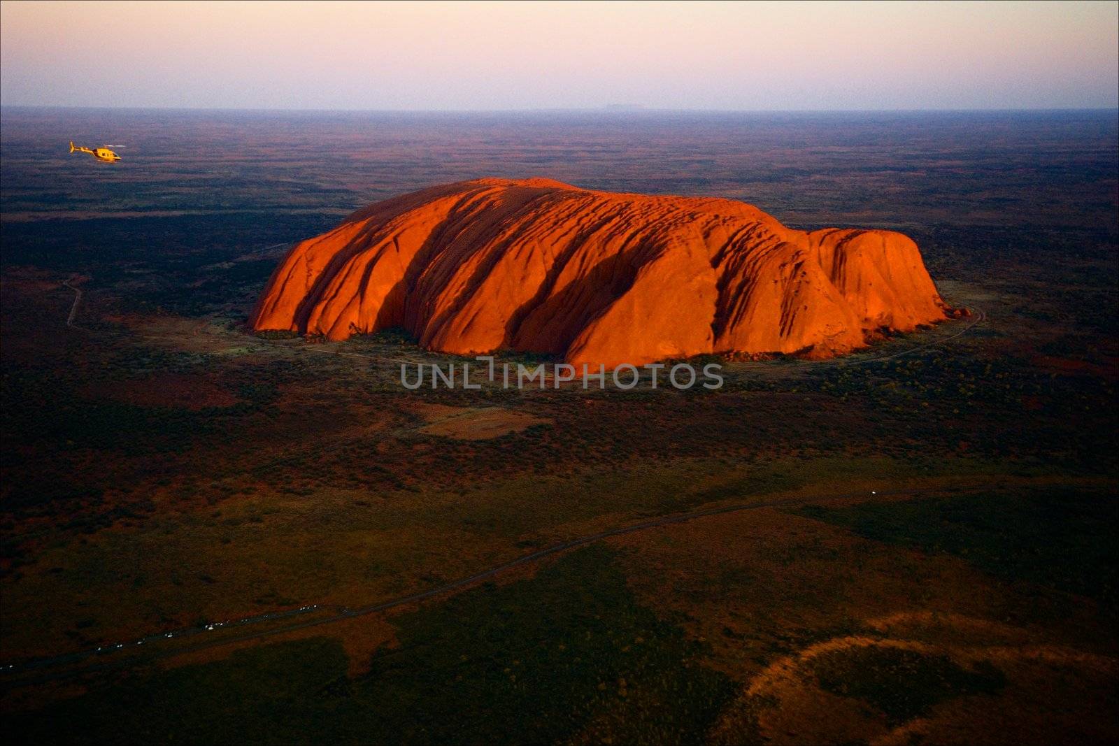 Uluru./ Orange Uluru in bright beams of the sunset sun. Aerial photography.