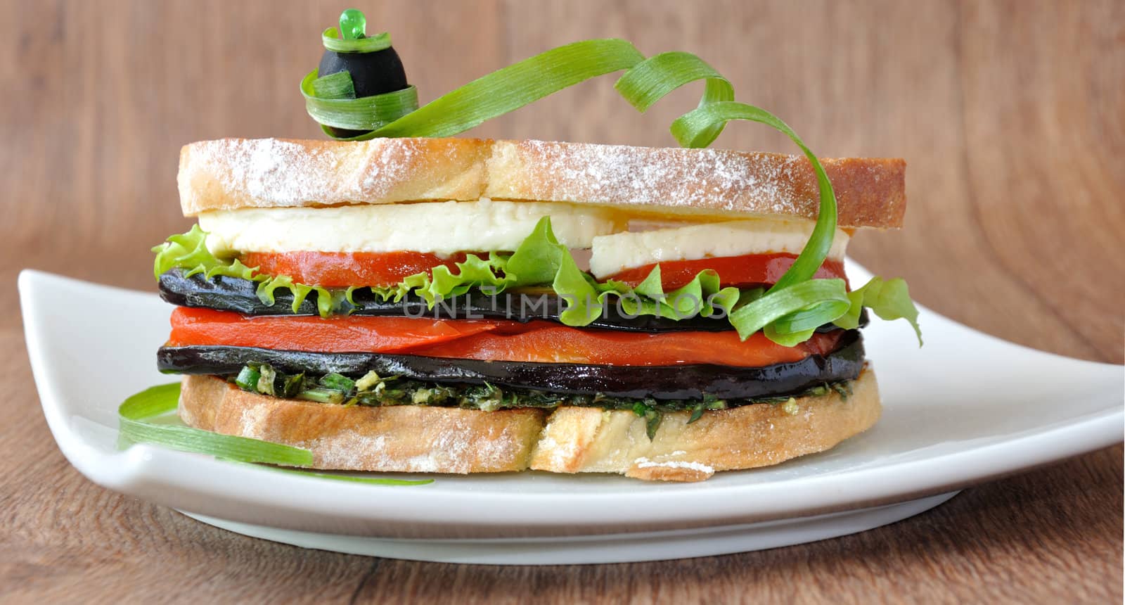 Sandwich with eggplant, tomatoes, peppers and cheese