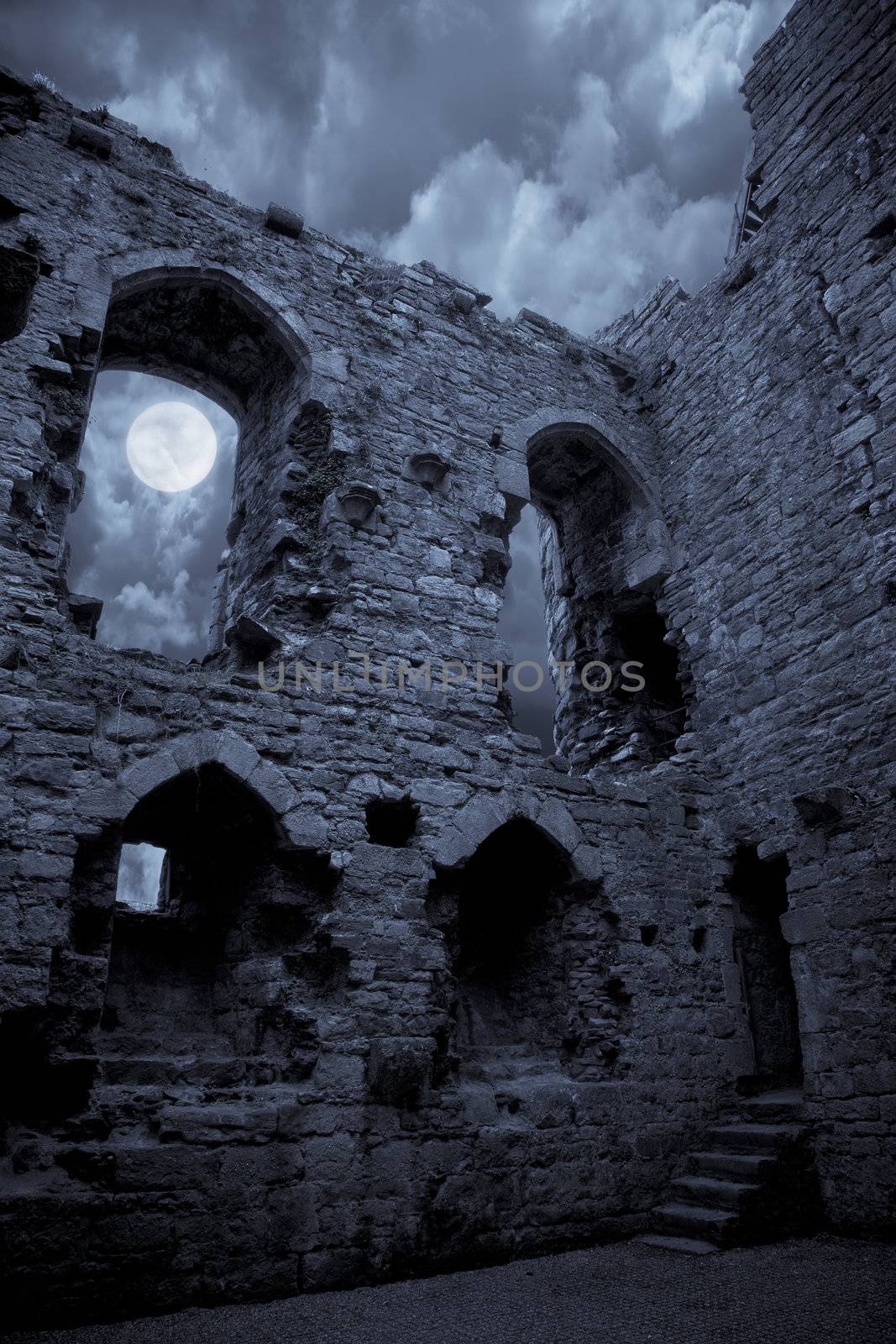 A very spooky castle in the moonlight, the moon is shining through a window.