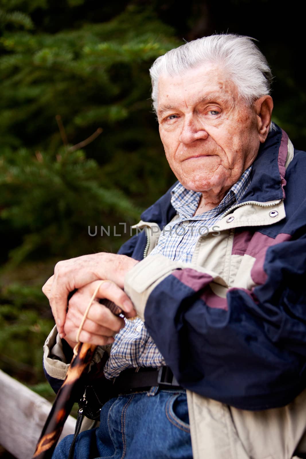 A portrait of an elderly man sitting looking at the camera