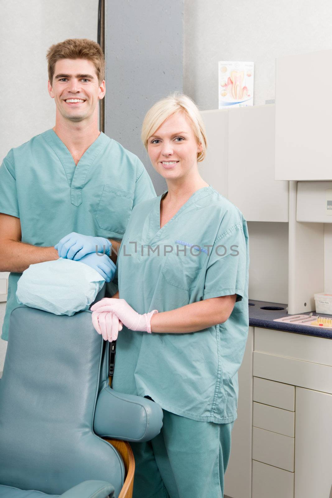 A happy dentist and assistant standing in a dental clinic