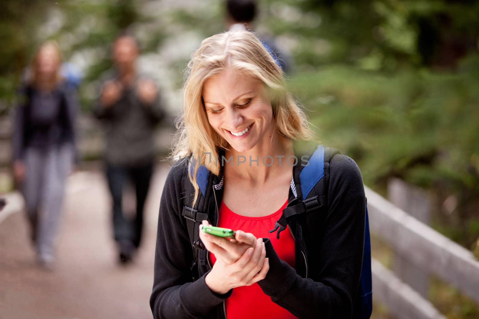 A young woman reading a friendly text while outdoors