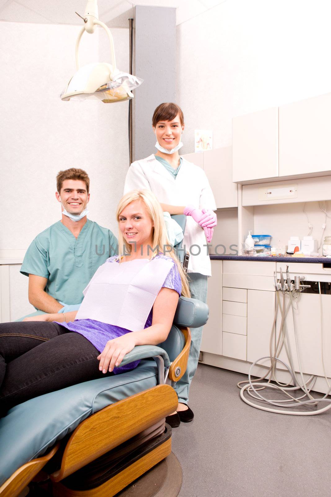 A dental clinic with dentist, assistant and patient