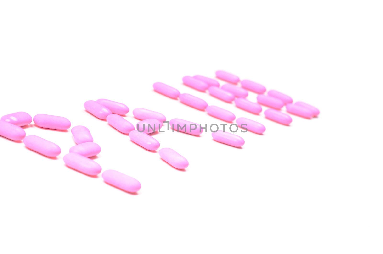 Shot of pink drugs (tablets) isolated on white