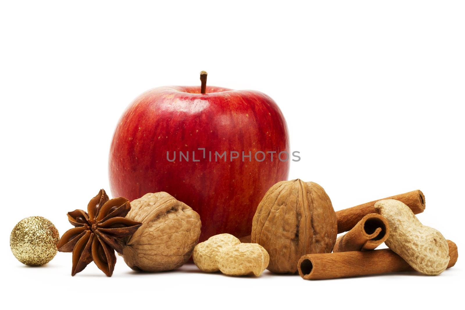 red apple, star anise, cinnamon sticks and some nuts  on white background