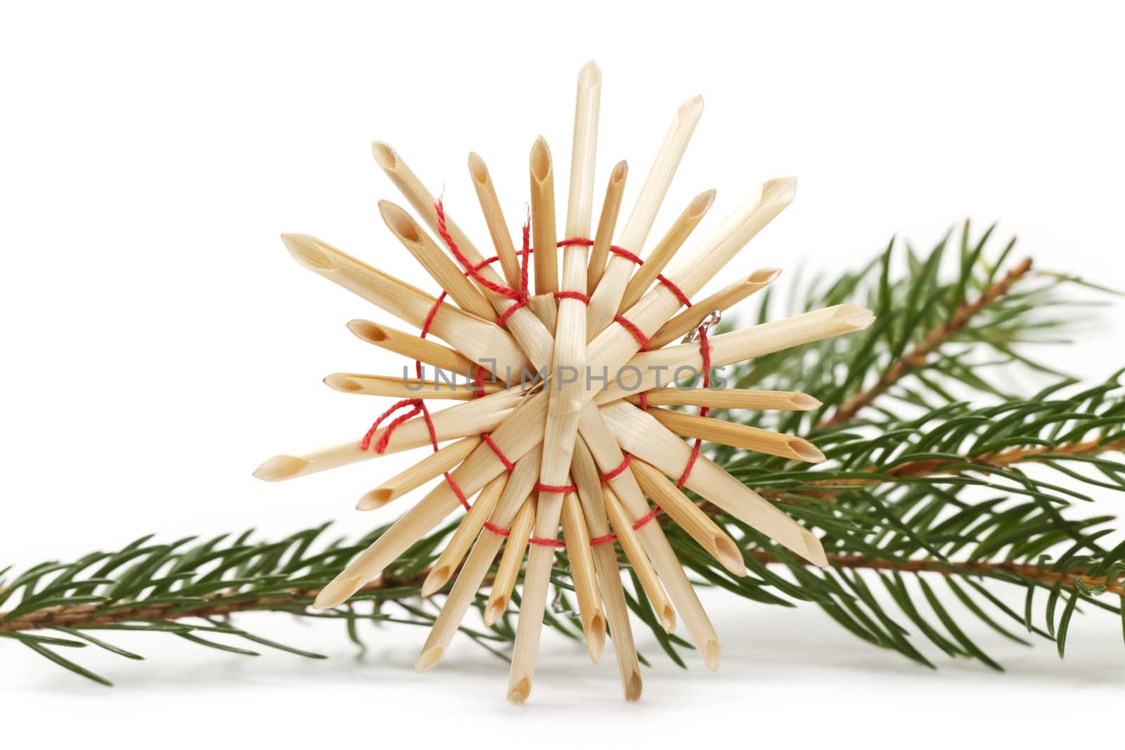 straw star in front of a branch on white background