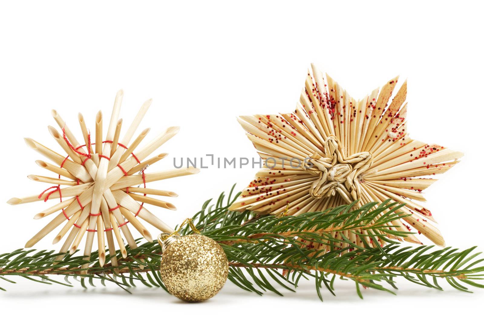 two straw stars and a glitter christmas ball and a branch on white background
