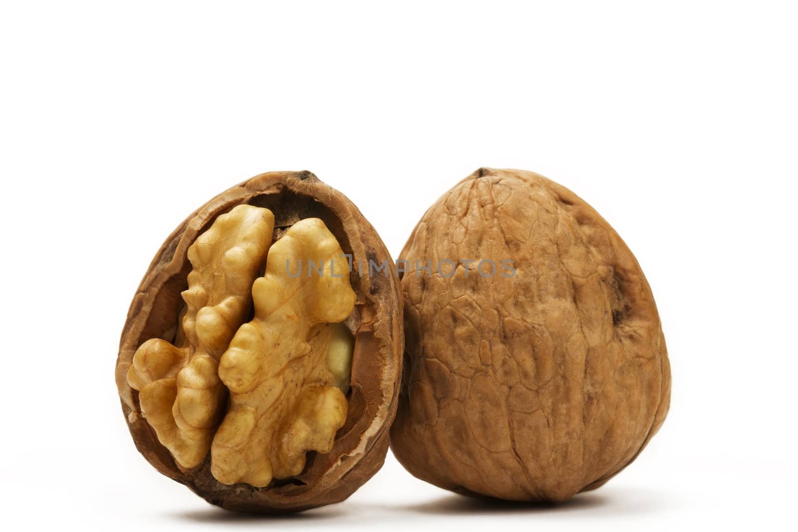walnut and a cracked walnut on white background
