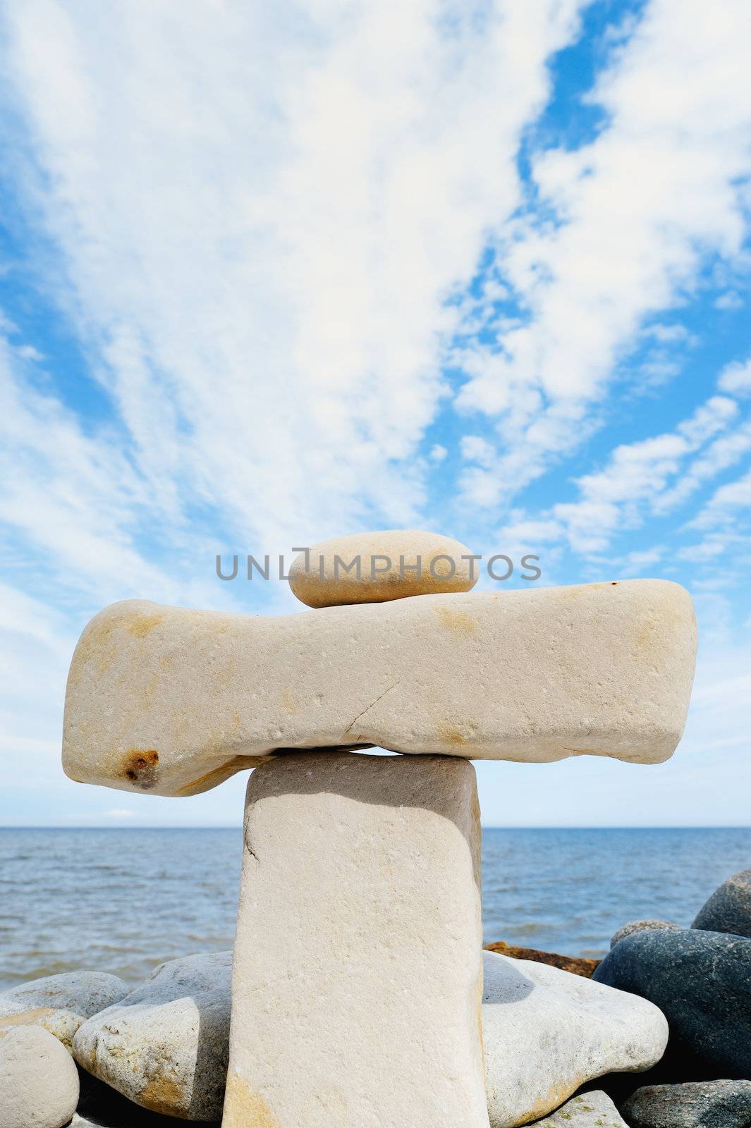 Small pebble on a large horizontal stone on seacoast