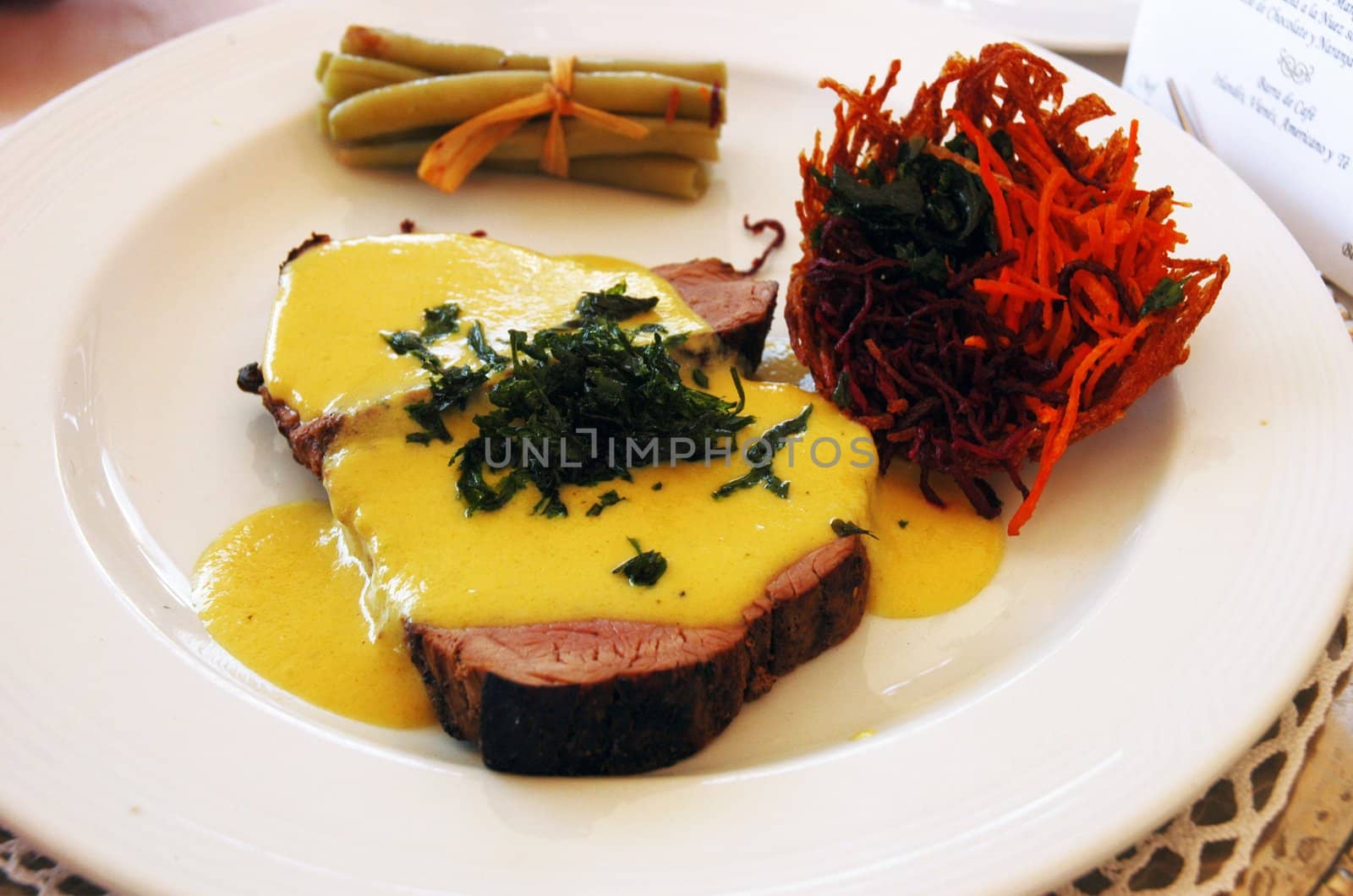 Delicious meat with yellow creamy sauce and vegetable