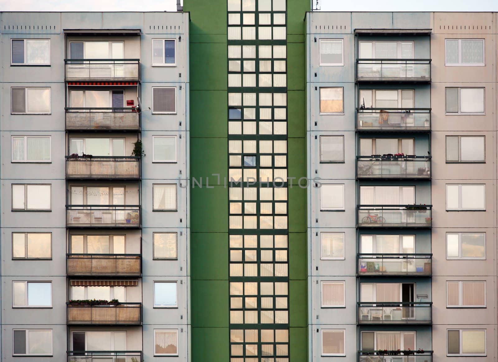 Green and grey prefab house with many balcons and windows