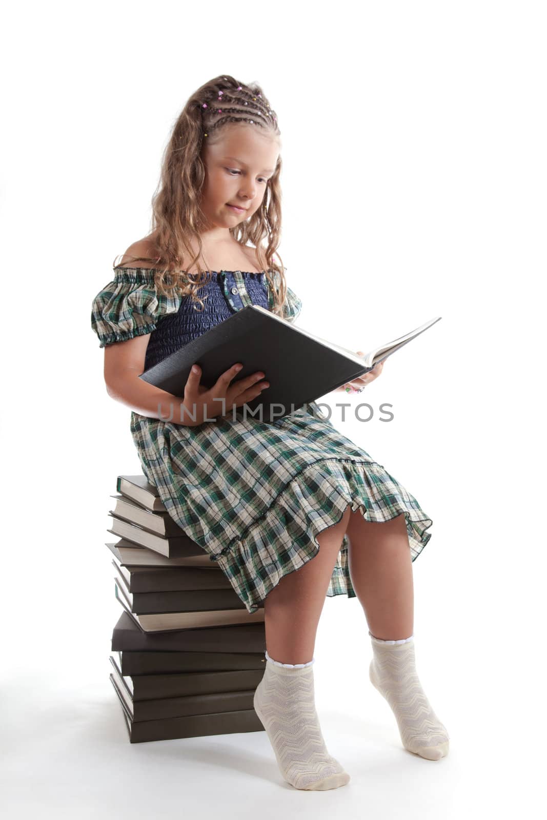 Cute little girl reading a book, isolated on white background 