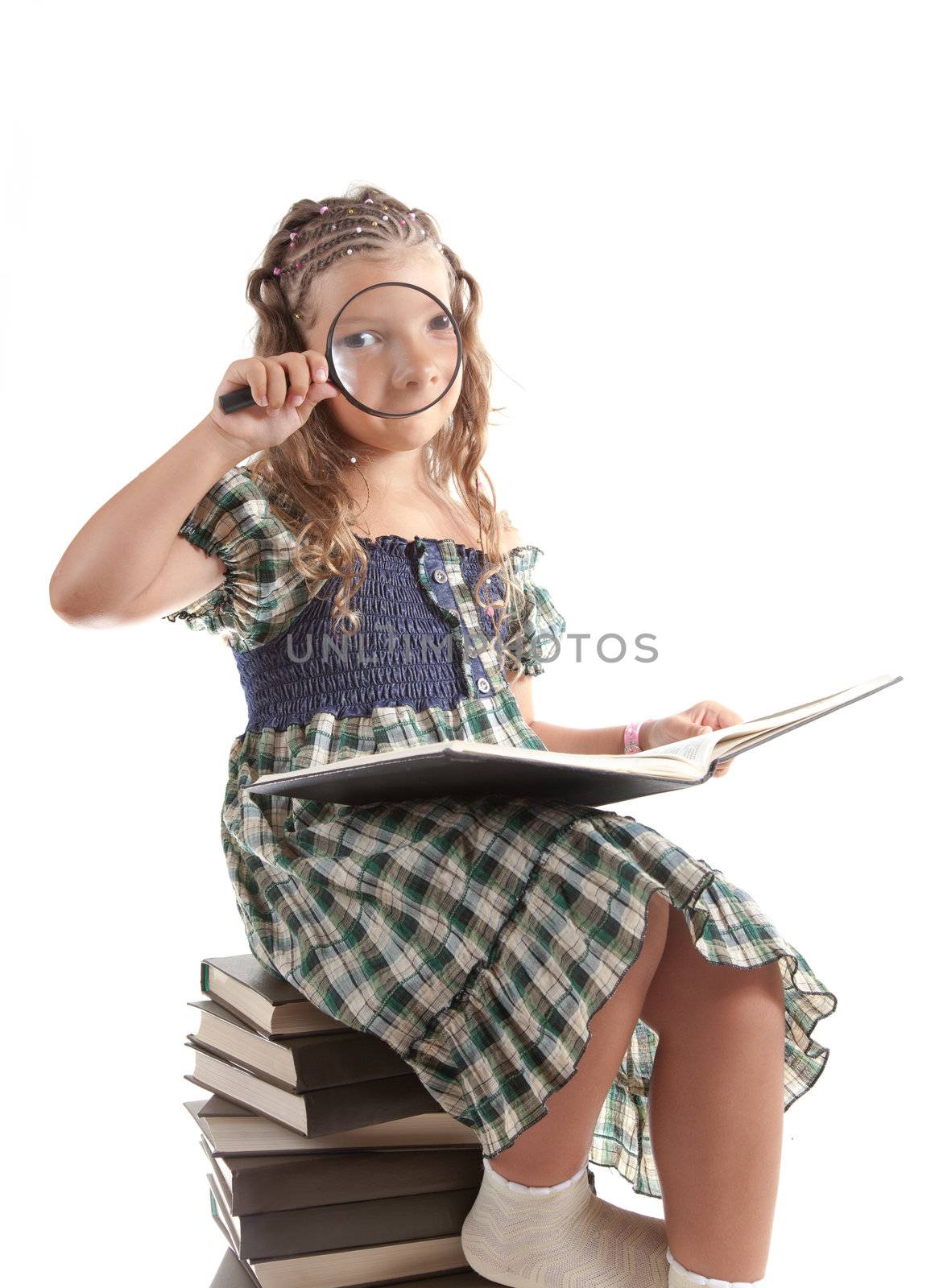 Funny shot of little girl looking through magnifying glass, isolated on white background 