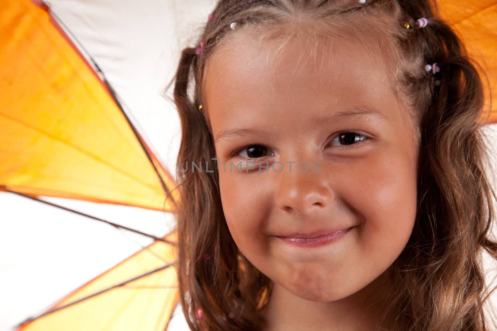 Close-up shot of cute little girl with orange umbrella 