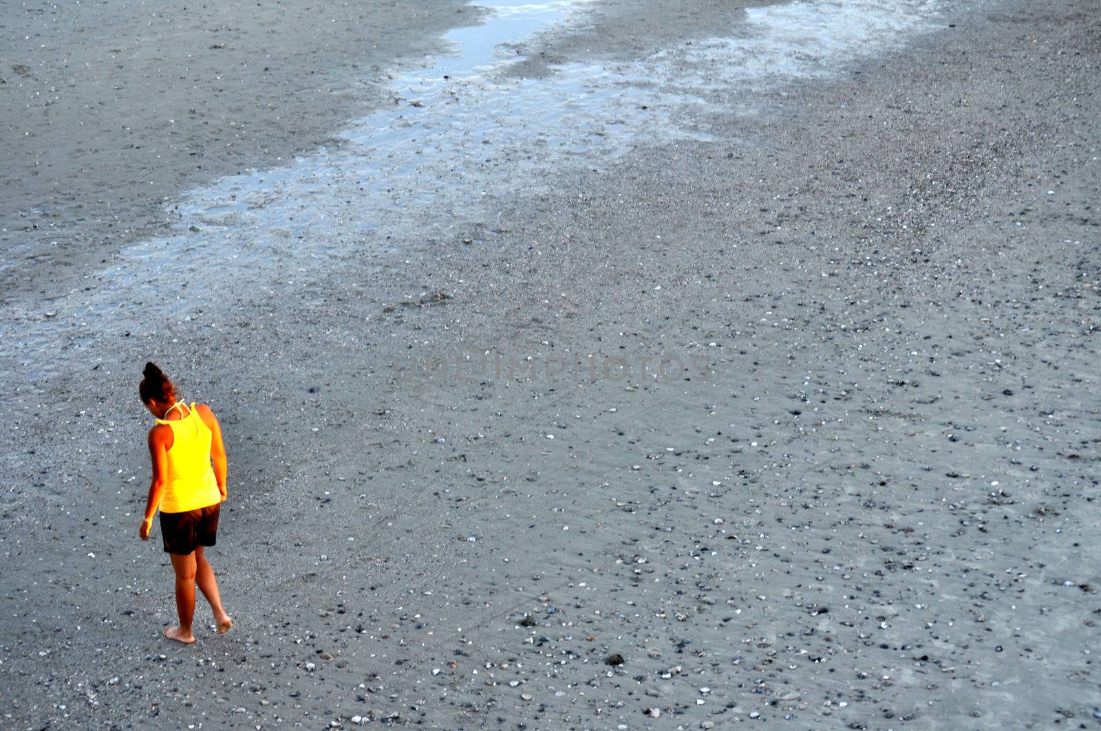 Lady in yellow looks for shells