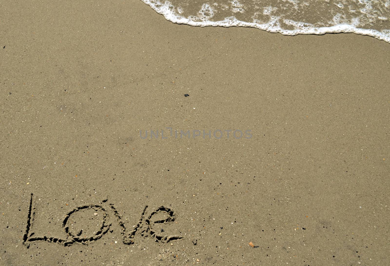 Love written in the sand with wave by RefocusPhoto