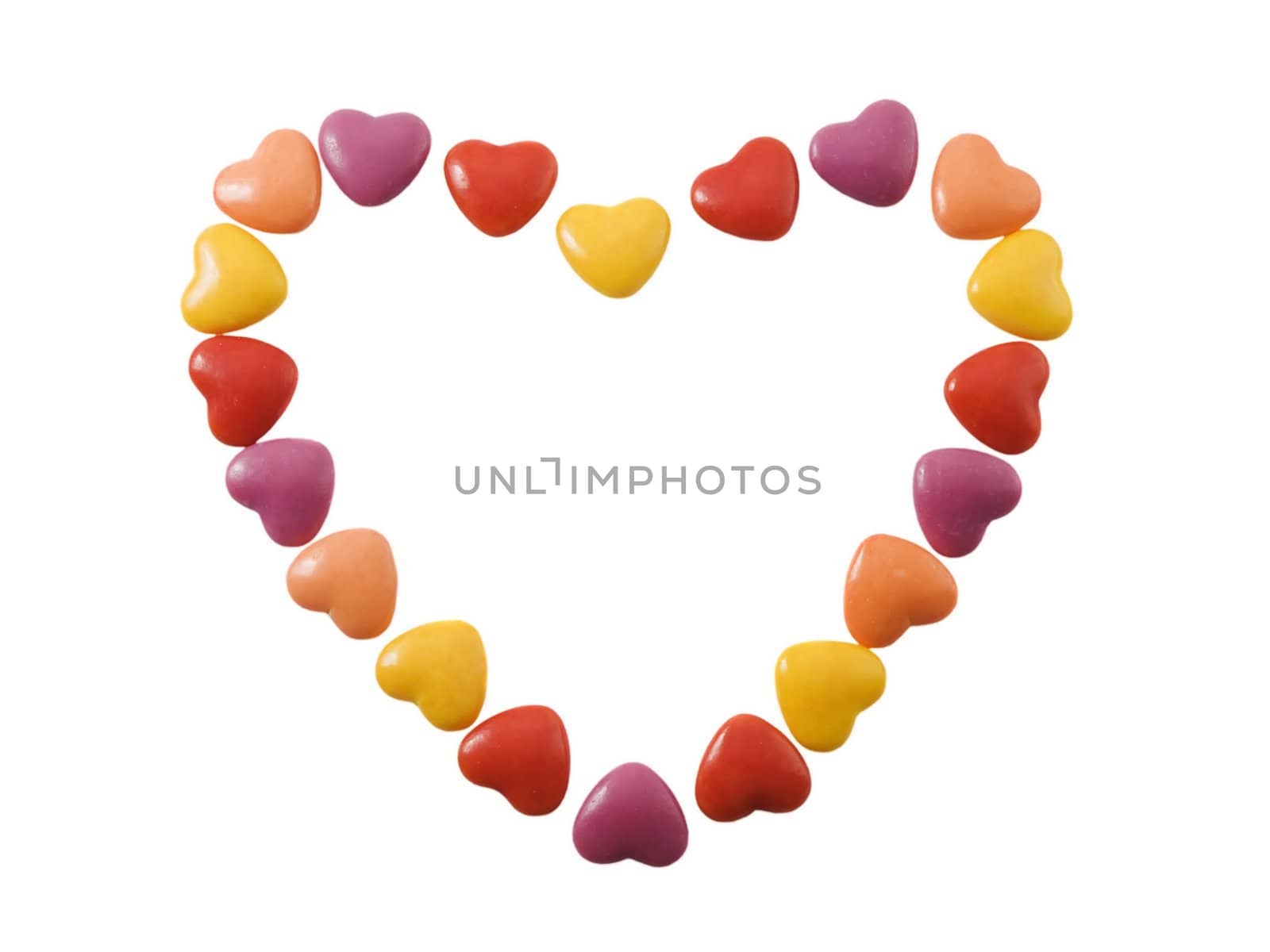 Heart shape made of small candy hearts isolated on white