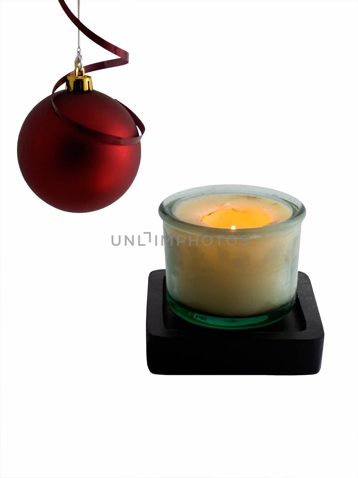 Christmas ornament and lit candle isolated on white