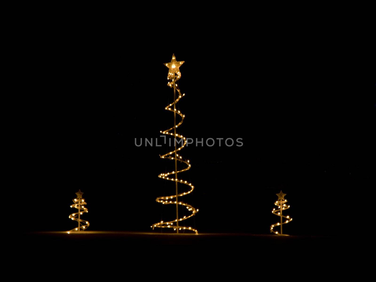 Three christmas tree decorations outside in the snow