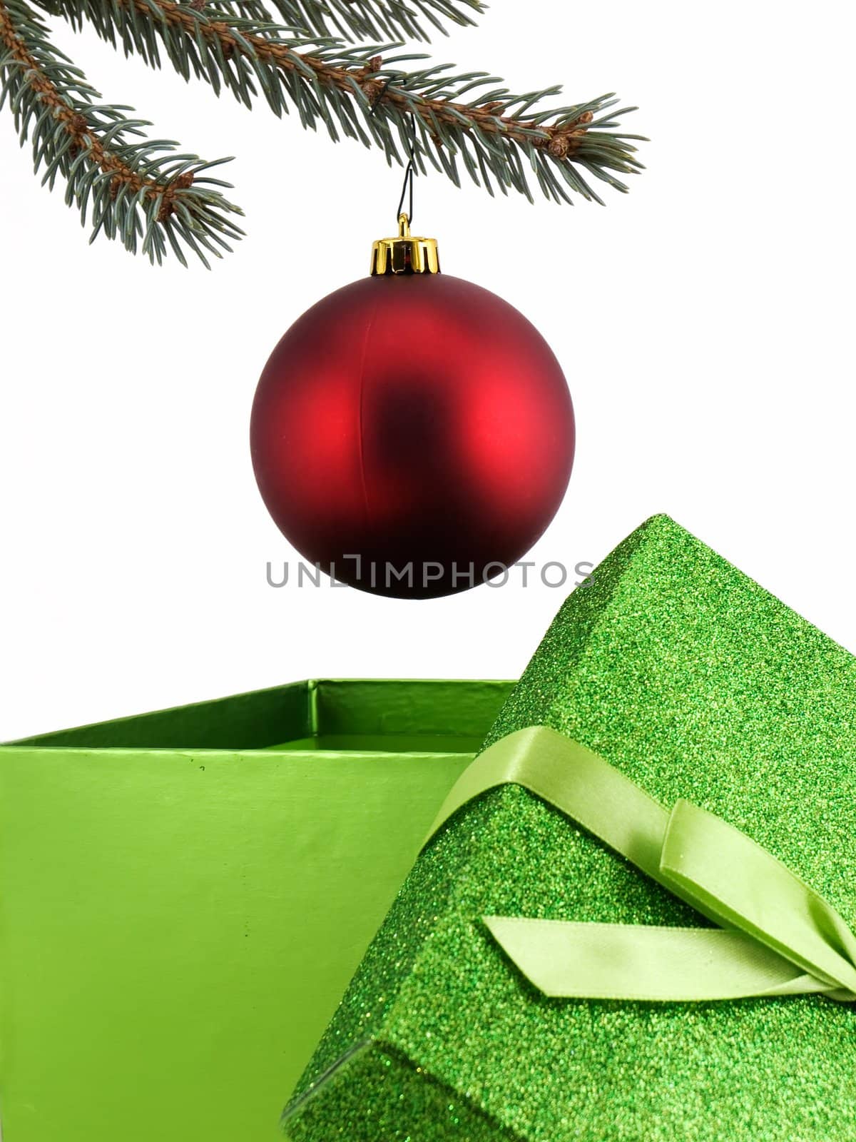 Christmas decoration hung from tree limb over open gift, isolated on white