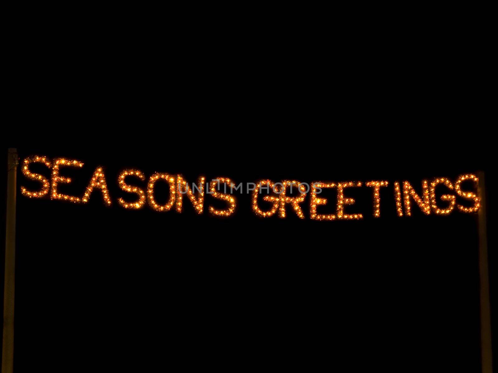 Seasons greetings lit up in lights at night time