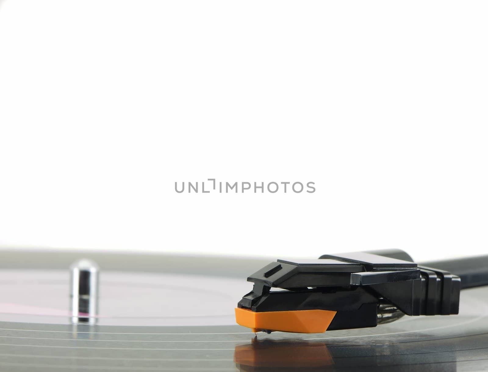 Vinyl record being played on a turntable close-up with the focus on the arm and needle