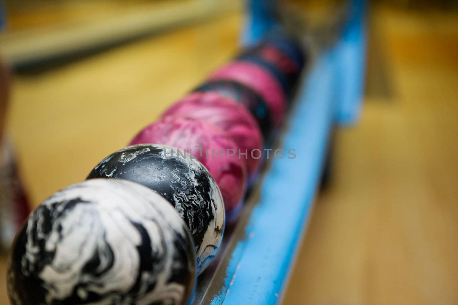 A close up detail image of a set of 5 pin bowling balls.  Shallow depth of field is used with focus on the second ball.
