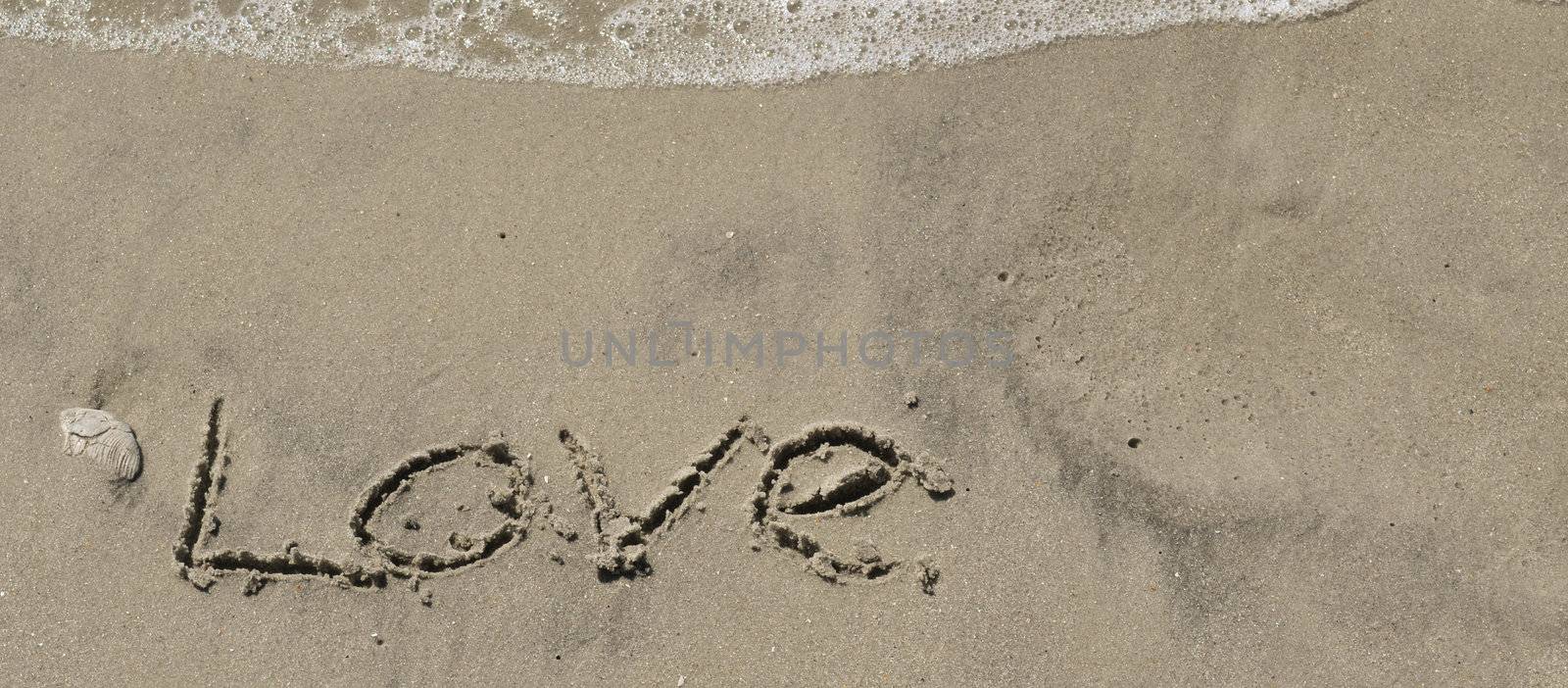 Love written in the sand with wave by RefocusPhoto