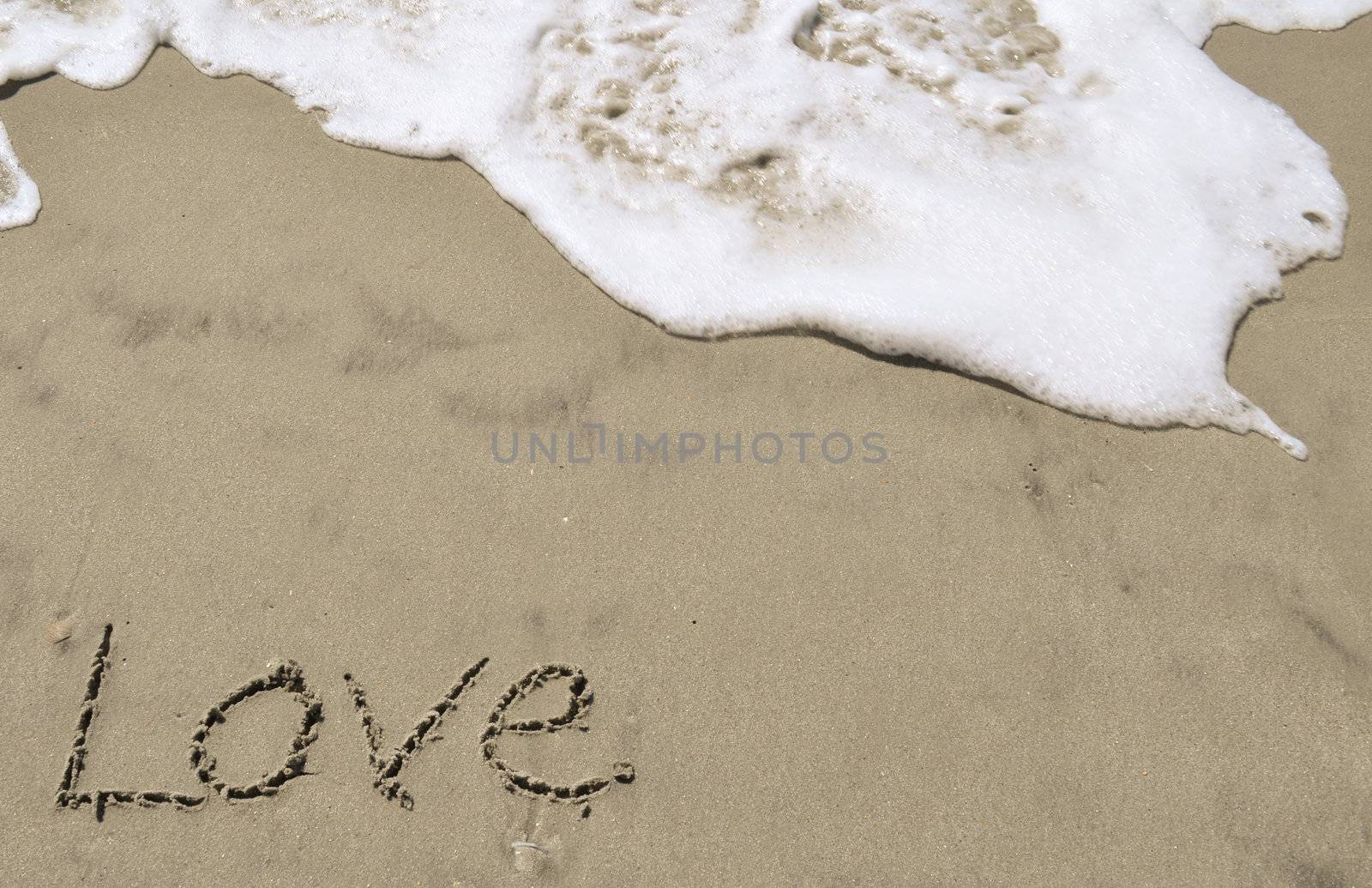 Love written in the sand with wave by RefocusPhoto