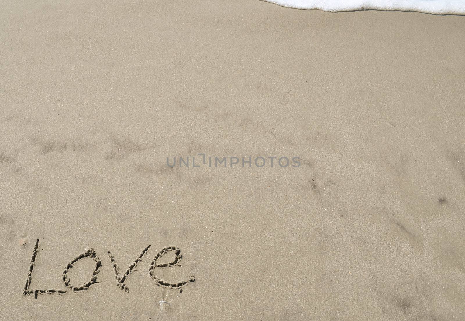 Love written in the sand with wave by RefocusPhoto