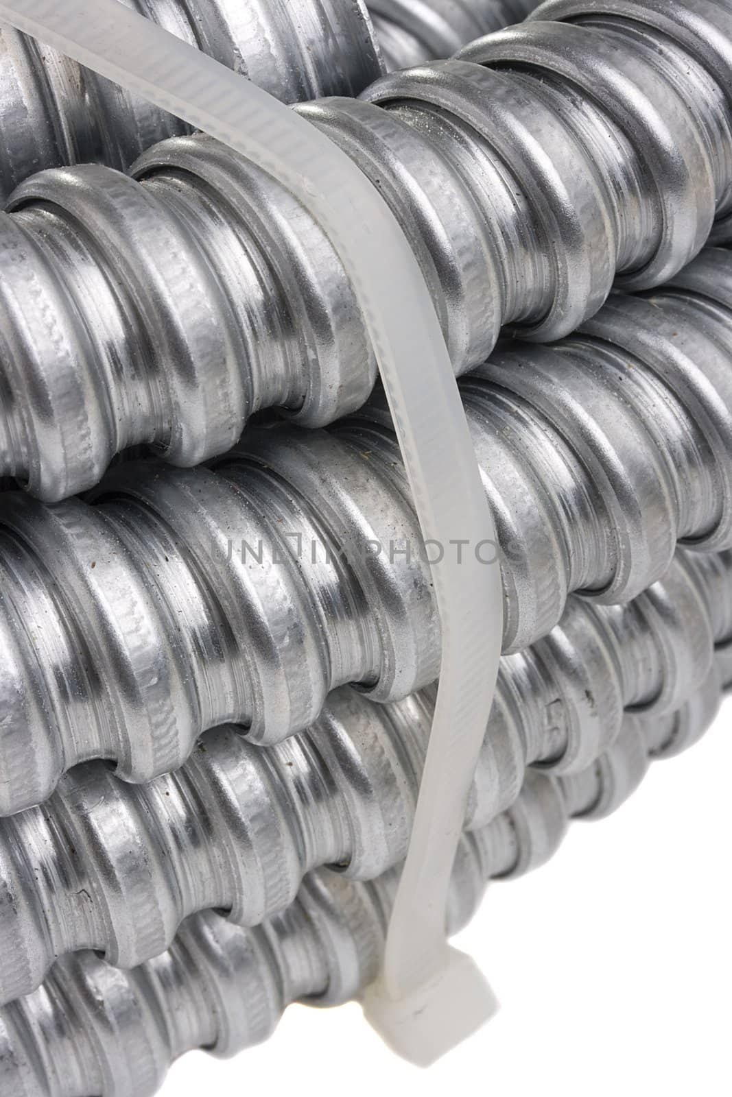 Packed metal cable protection conduit on a white background.