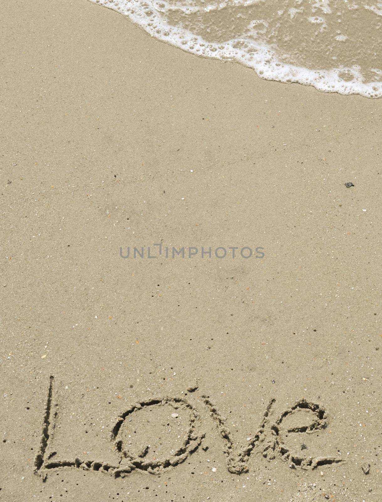 Love written in the sand with wave by RefocusPhoto