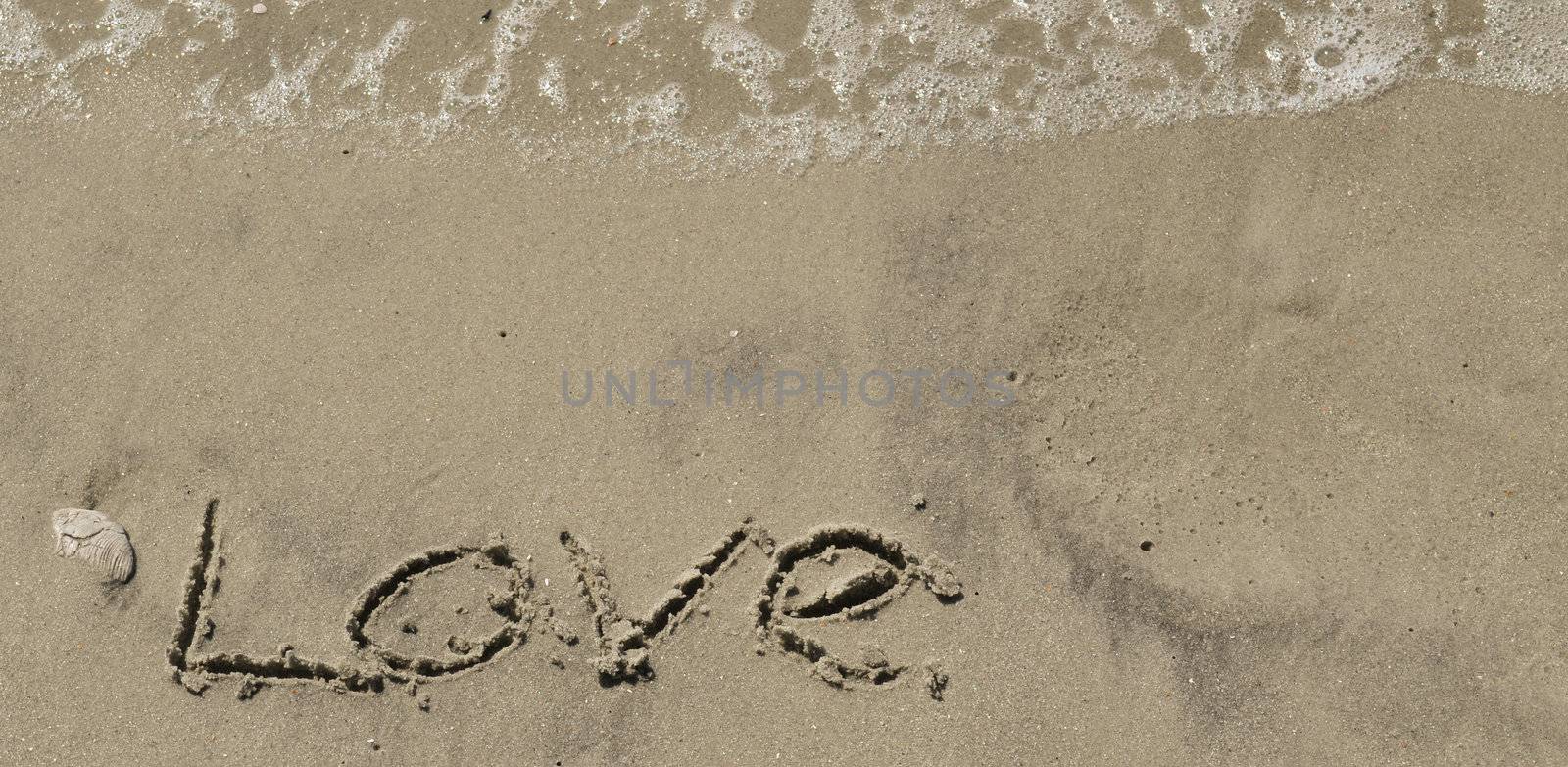 Love written in the sand with wave by RefocusPhoto