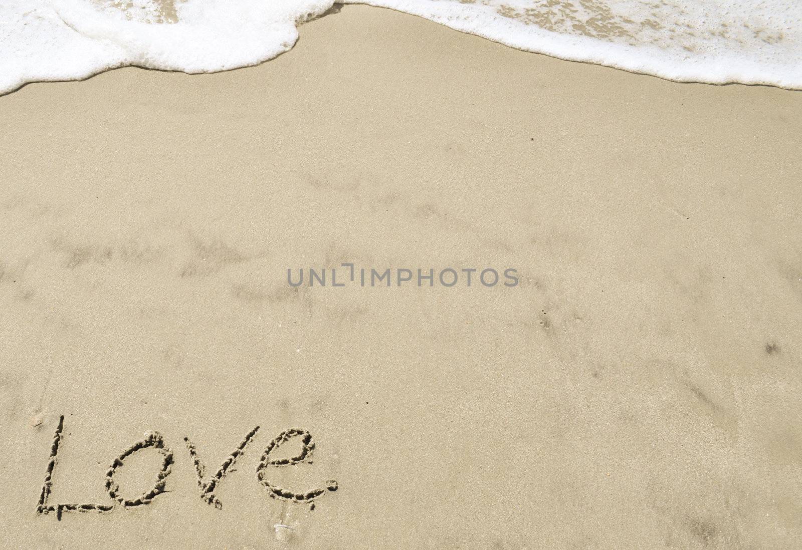 Love written in the sand with wave by RefocusPhoto